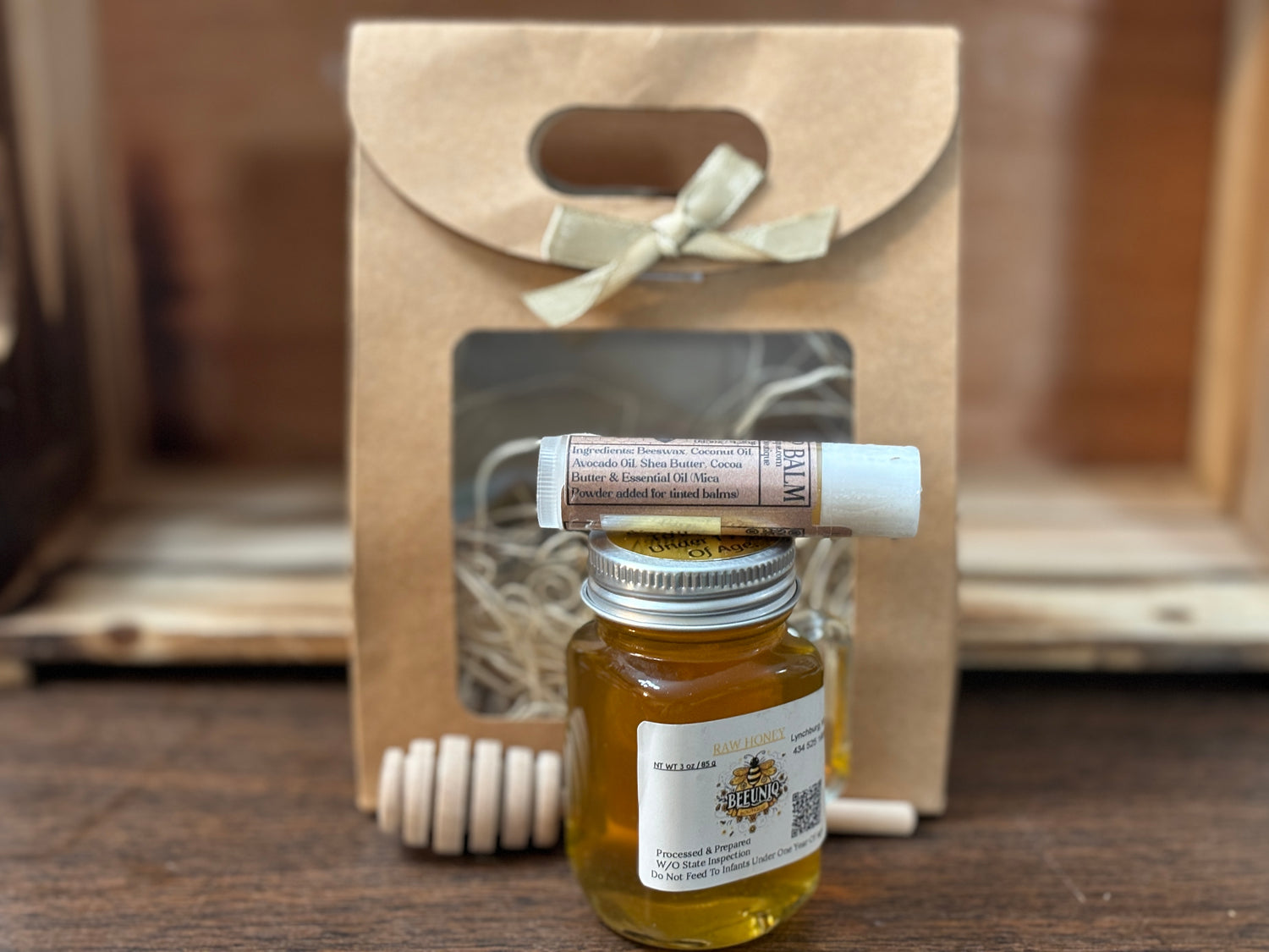 Gift bag with honey & drizzler stick and tube of lip balm. 