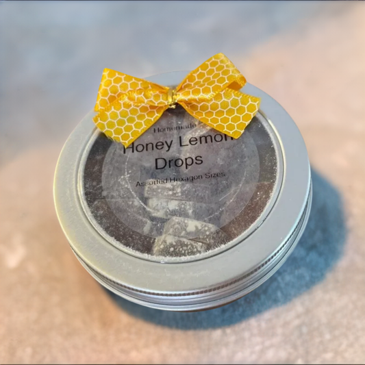 Tin with yellow bow containing honey lemon drops.